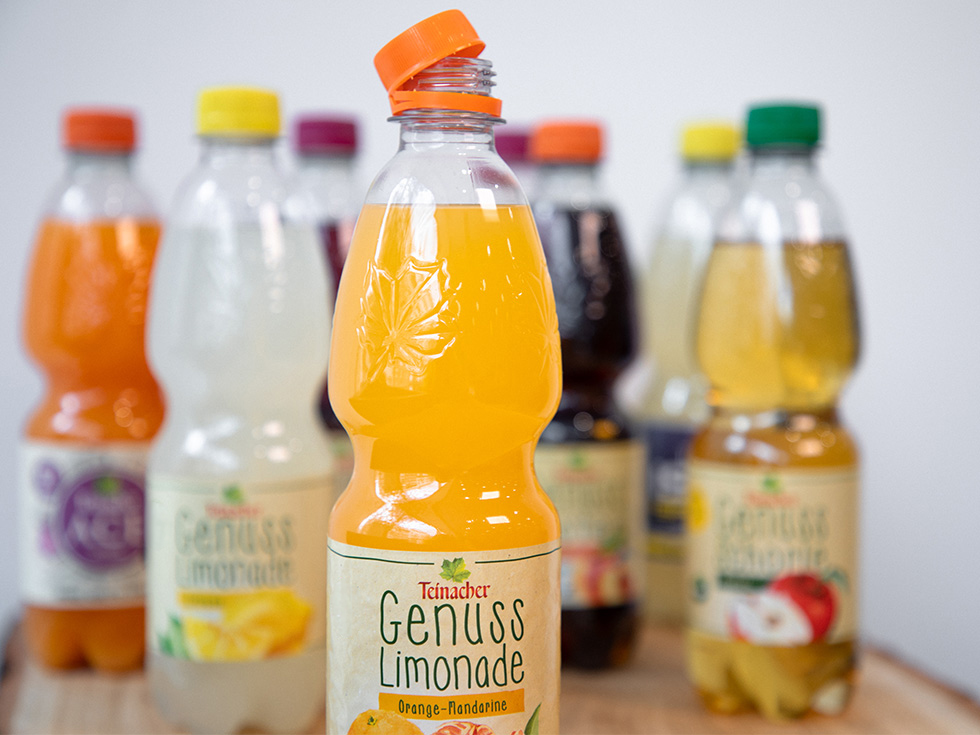 Geöffnete Teinacher Genuss-Limonade Orange-Mandarine in PET-Flasche vor weiteren Teinacher Getränken
