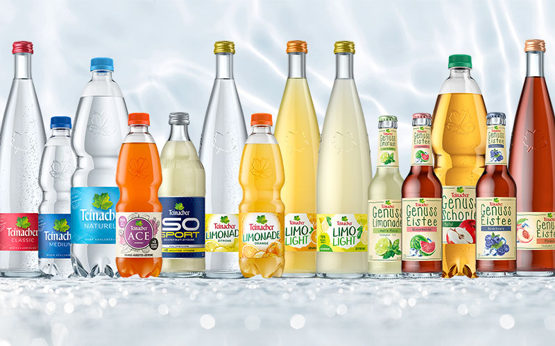 Teinacher Sortiment mit Mineralwasser, Limonade, Sportgetränk, Genuss-Schorle und Genuss-Eistee vor hellem Wasserhintergrund