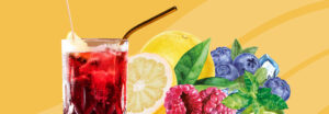 Roter Mocktail mit Eiswürfeln und Zitronenscheibe im Glas, umgeben von Himbeeren, Blaubeeren, Zitrone, Minze und Eiswürfeln.