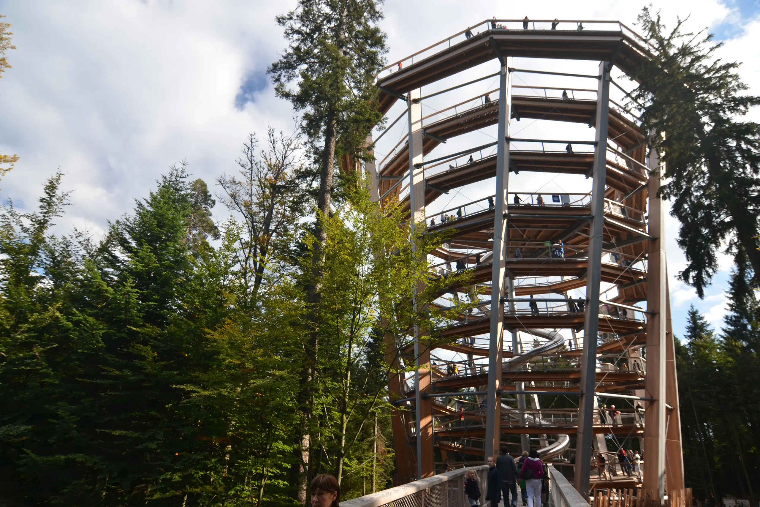 Aussichtsturm am Baumwipfelpfad im Schwarzwald zwischen hohen Bäumen mit Besucherinnen und Besuchern