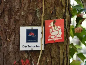 Wegweiser für den Genießerpfad Der Teinacher an einem Baum im Schwarzwald