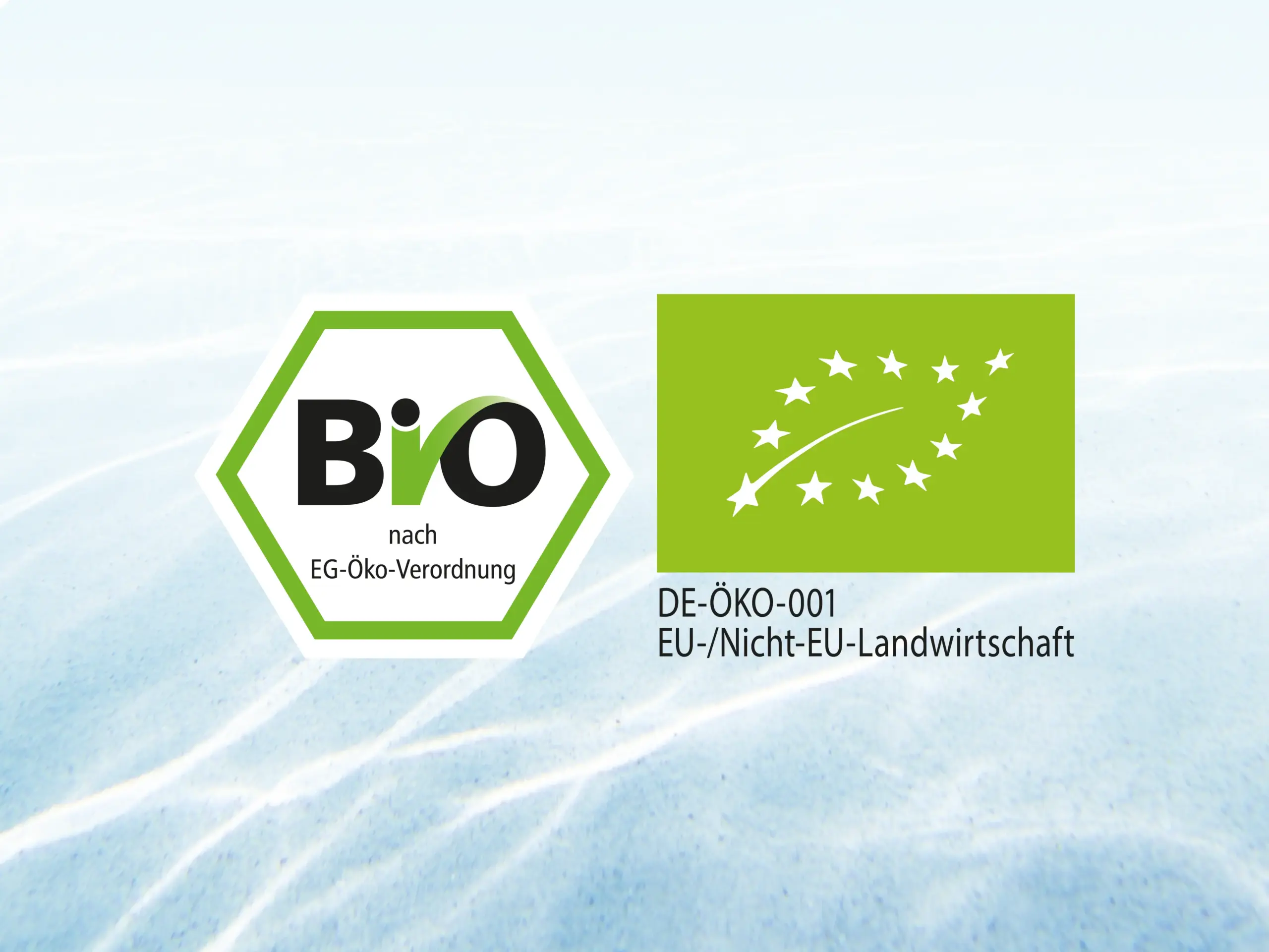 Bio- und EU-Öko-Siegel vor hellem Wasserhintergrund als Hinweis auf natürliches Bio-Aroma bei Teinacher