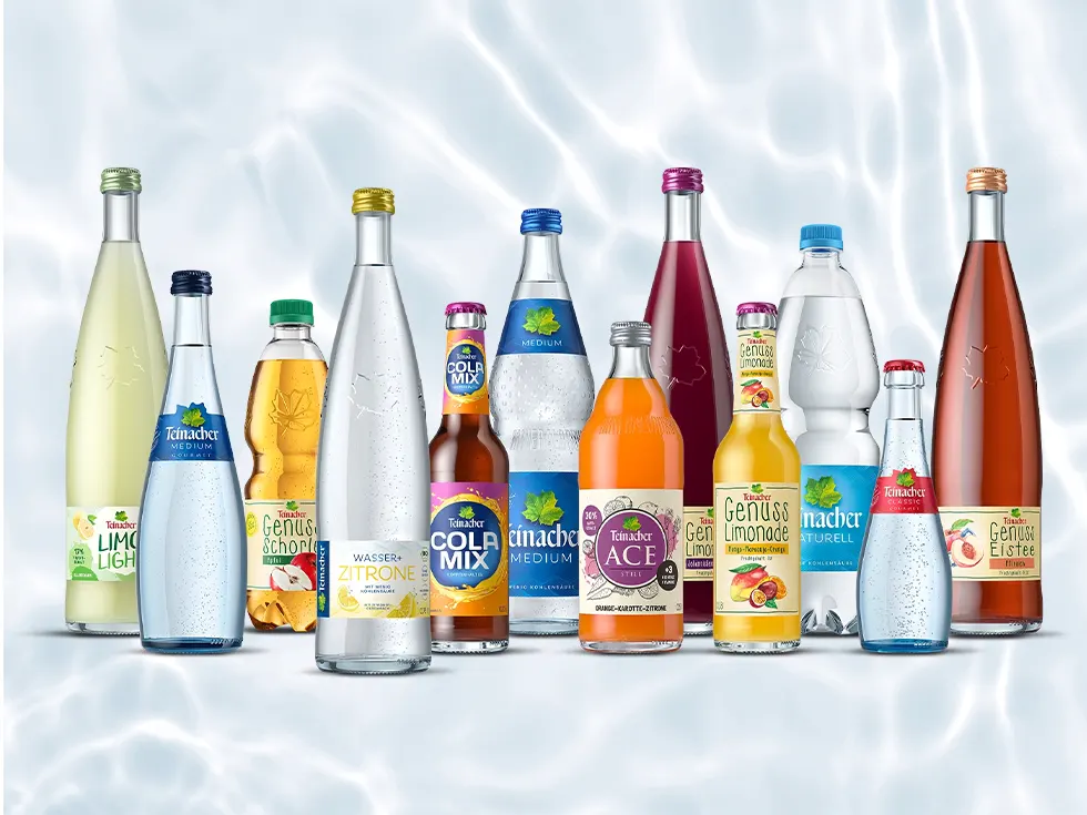 Teinacher Produktsortiment mit Mineralwasser, Limonaden, Schorlen, Cola-Mix und Eistee vor hellem Wasserhintergrund