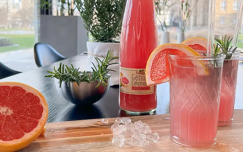 Zwei Gläser Mocktail Grapefruit Rosmarin Spritz Mocktail mit Teinacher Genuss Limonade Pink Grapefruit mit Frucht