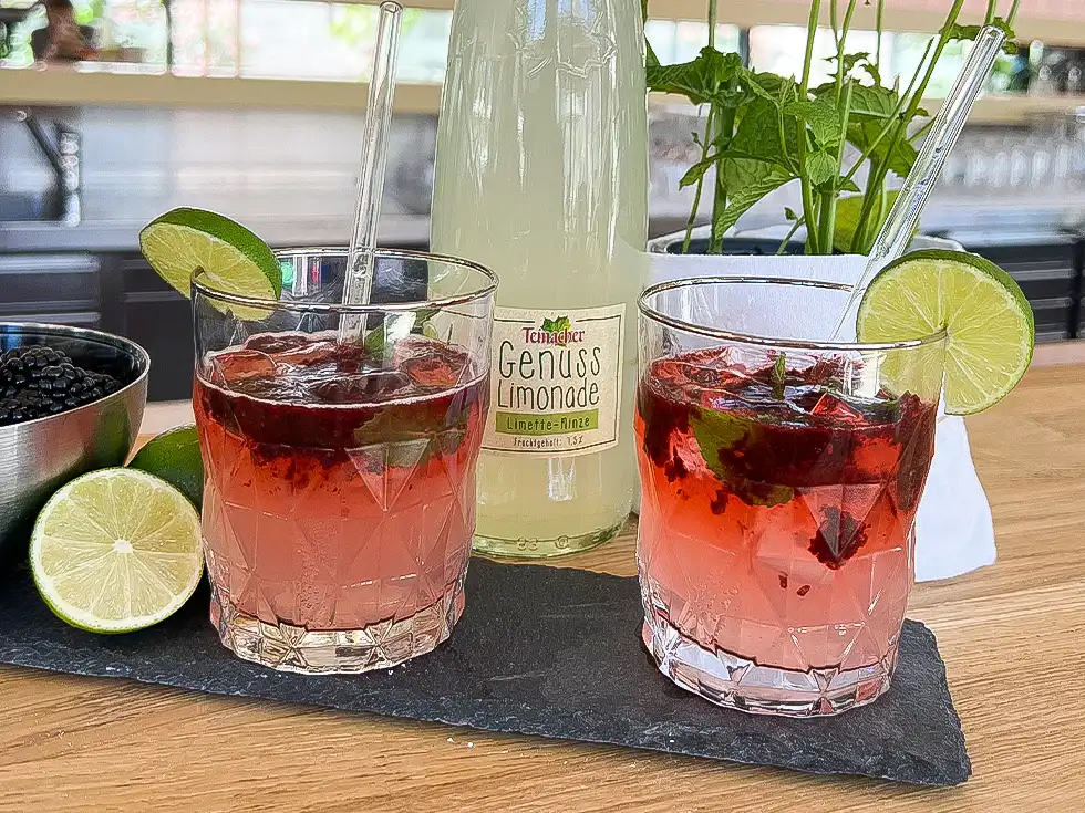 Zwei Gläser Bramble Mocktail mit Teinacher Genuss-Limonade Limette-Minze