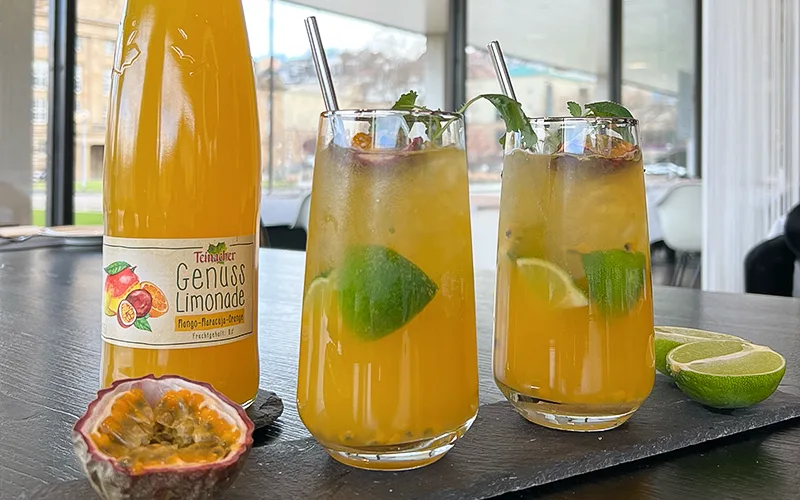 Zwei Gläser Mocktail Maracuja-Limetten-Mocktail mit Teinacher Genuss Limonade Mango-Maracuja-Orange Maracuja-Limetten