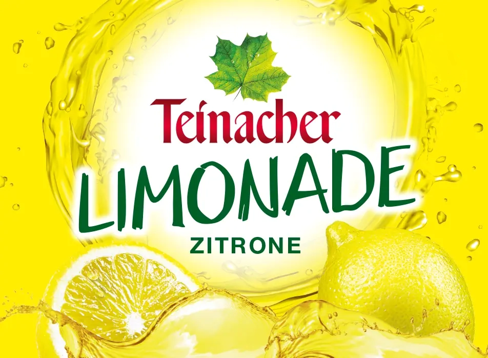 Teinacher Limonade Zitrone mit frischen Zitronen und spritzigem Wasser auf gelbem Hintergrund