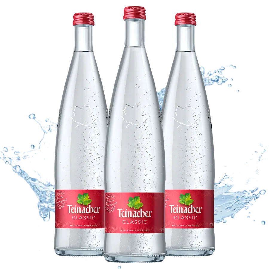 Drei Teinacher Mineralwasser Classic Genussflaschen 0,75 L mit Wasserspritzer im Hintergrund