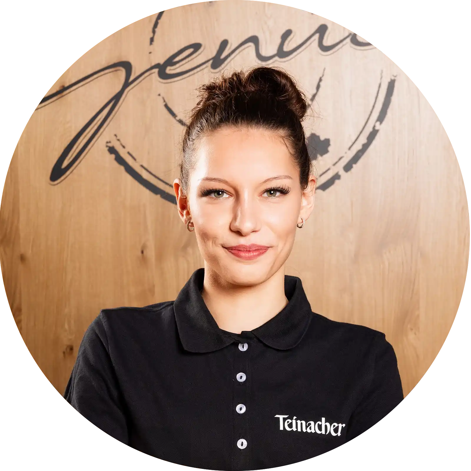 teinacher-rezepte-summer-spritz-portrait-katharina-garcia Junge Frau in Teinacher-Shirt lächelt vor Holz-Hintergrund mit „Team Genuss“-Schriftzug.