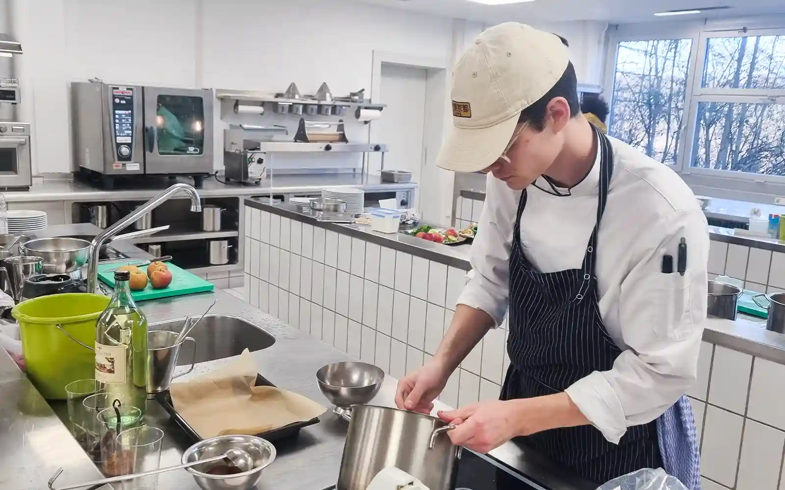 Junger Koch in Ausbildung bereitet Speise in moderner Lehrküche am DEHOGA Campus Calw zu.