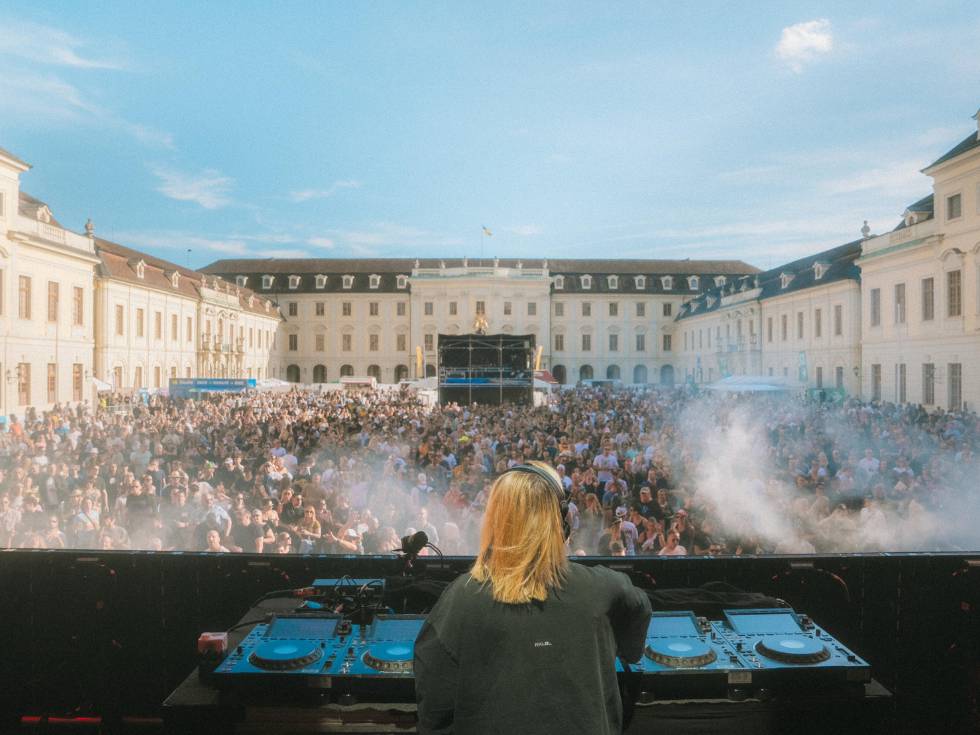 DJ vor großer Menschenmenge beim Event „Crown of Sound“ im Schlosshof bei Sonnenschein