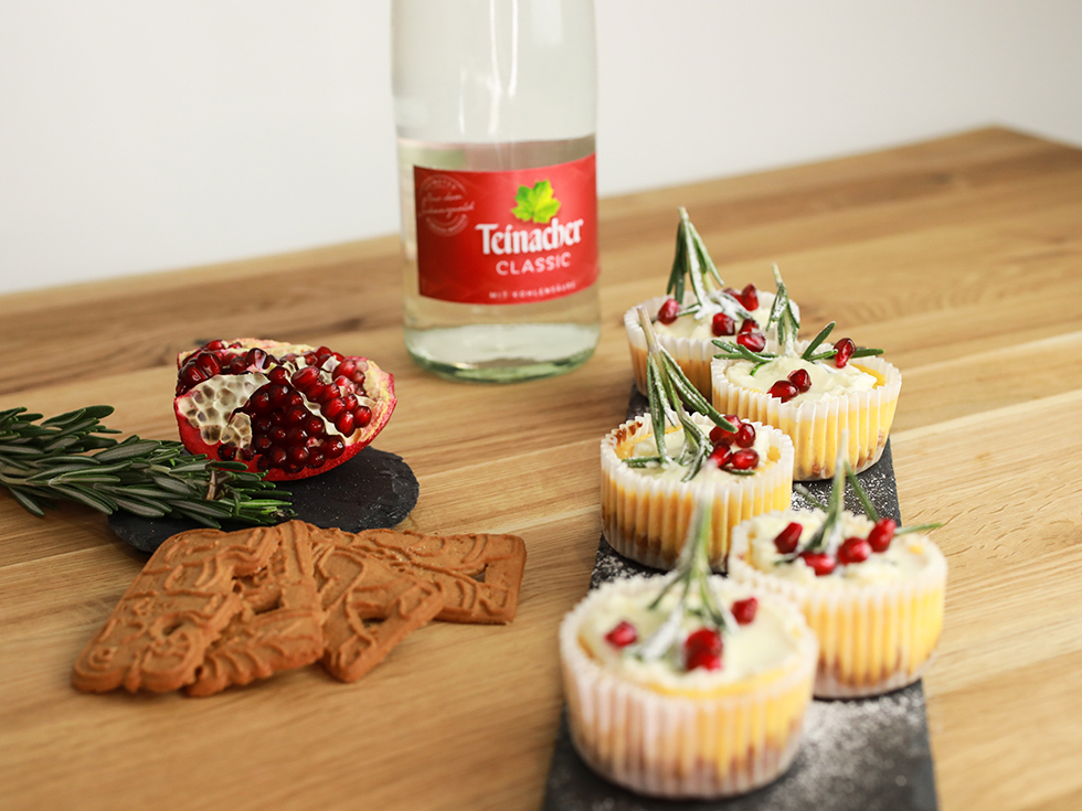 Vorderansicht einer Teinacher 1 Liter Genussflasche mit Muffins und Spekulatiuskekse im Vordergrund